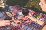 couple having a picnic date drinking a glass of wine